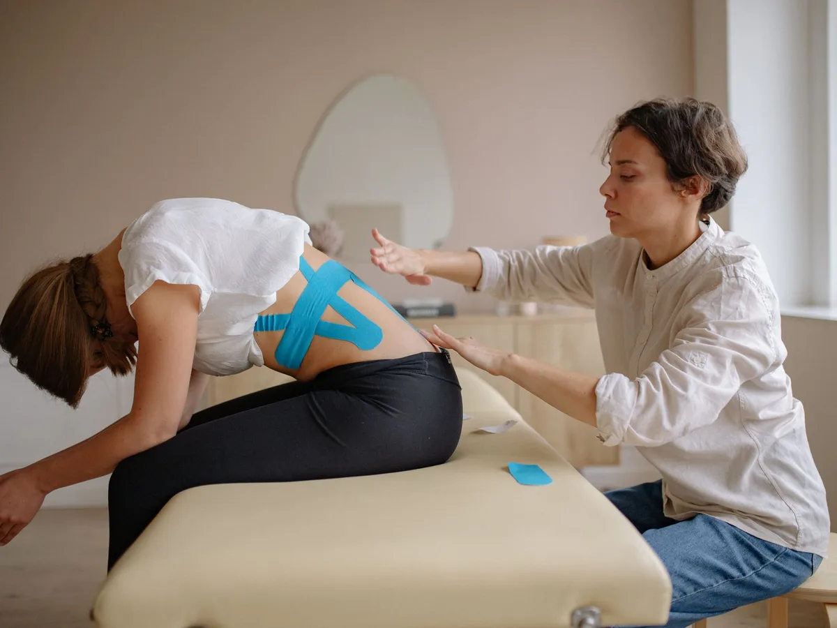 Aplicación de vendaje neuromuscular en el hombro de una paciente